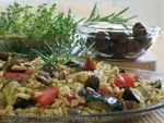 Mediterranean food highlighting black olives and fresh herbs.