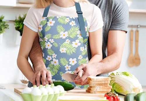 Light blue and green floral apron with wide pocket and adjustable straps.