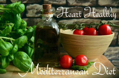 Heart-Healthy Mediterranean Diet words overlayed on picture of basil bunch, red tomatoes, and bottle of extra virgin olive oil.