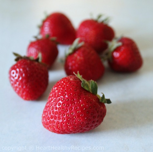 Close-up of fresh strawberries on marble counter.