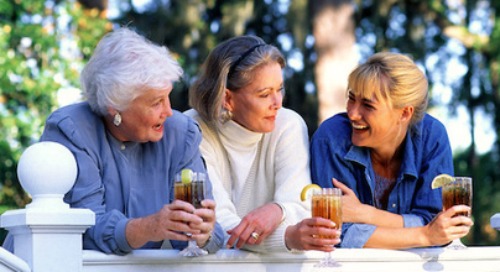 Three women relaxing and drinking iced tea beverage.