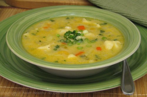 Cod fish chowder soup with chopped green onions as garnish.