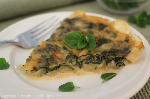Sweet Potato Quiche slice garnished with oregano sprig and leaves.