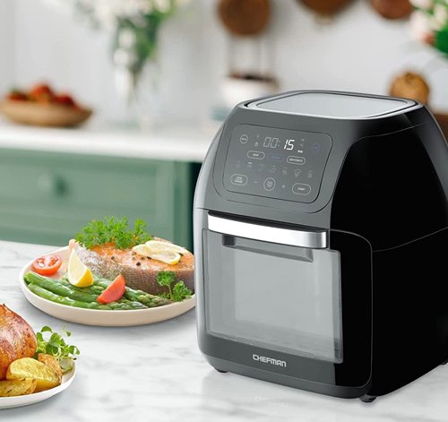 Chefman Multifunctional Digital Air Fryer displayed on marble counter with kitchen background and food on plates.