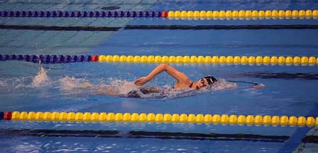 Swimmer swimming in pool with marked lanes.