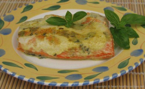 Salmon topped with sauce and basil sprig.