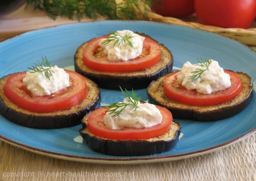 Tomato eggplant appetizer topped with heart healthy egg-free mayonnaise alternative and garnished with dill weed sprig.