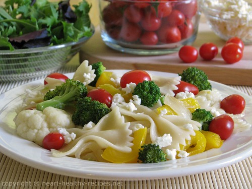 Veggie pasta with tomatoes, broccoli, cauliflower, and yellow peppers.